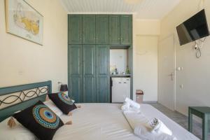 a bedroom with a bed with a green cabinet at Odysseia Beachside Apartments in Nikiana