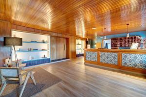 a living room with a wooden ceiling and a chair at Apartamentos MultiBaqueira in Baqueira-Beret