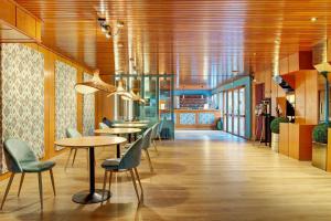 a restaurant with tables and chairs and wooden ceilings at Apartamentos MultiBaqueira in Baqueira-Beret