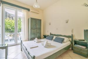 a bedroom with a bed and a balcony at Odysseia Beachside Apartments in Nikiana