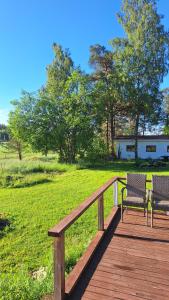 two benches sitting on a wooden boardwalk in a field at Kivimäen Matkailutila in Masku