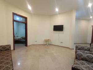 a living room with a couch and a tv on a wall at ROYAL VILLA Bhurban in Murree