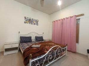 a bedroom with a bed and a pink curtain at ROYAL VILLA Bhurban in Murree
