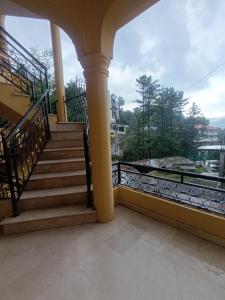 a balcony with stairs and a view of a building at ROYAL VILLA Bhurban in Murree