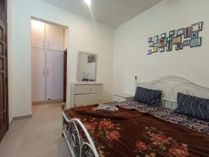 a bedroom with a bed and a dresser at ROYAL VILLA Bhurban in Murree