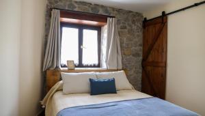 a bedroom with a bed with a window and a door at Posada VALLE DEL ASON in Ogarrio