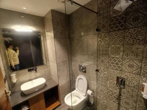 a person taking a picture of a bathroom with a toilet and sink at La Casa De Landour in Mussoorie +48 photos
