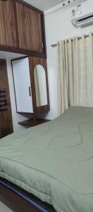 a bedroom with a bed with a mirror and a window at Ocean wings Traditional beach villa in Kaipamangalam
