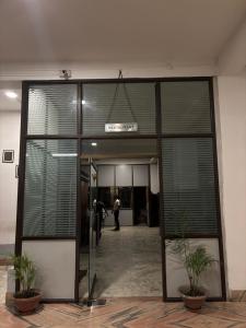 a large glass door in a building with two plants at Hotel Nikita in Jorhat