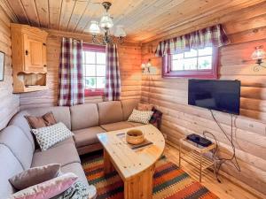 a living room with a couch and a tv in a log cabin at 4 person holiday home in gol in Gol