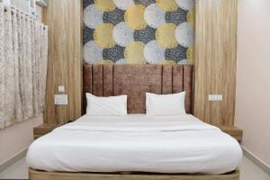 a bedroom with a large white bed with a painting on the wall at Hotel Ganga Ram in Chitrakoot