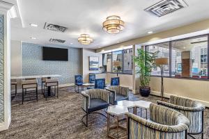 a lobby with chairs and tables and a tv at DoubleTree by Hilton Milwaukee Downtown in Milwaukee