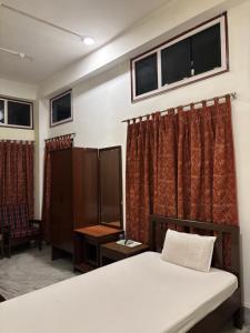 a bedroom with a bed and some windows at Hotel Nikita in Jorhat +40 photos