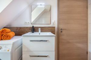 a bathroom with a sink and a washing machine at Ferienwohnung Seeblick in Bad Bodenteich +37 photos
