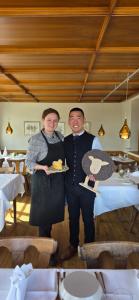 a man and a woman holding a plate of food at Hotel Adler Bärental in Feldberg