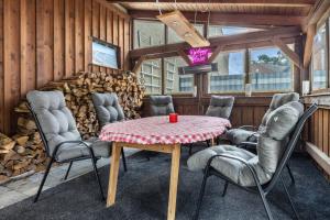a room with a table and chairs and a pile of logs at Ferienwohnung Seeblick in Bad Bodenteich