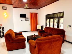 a living room with two couches and a tv at Orchid Resort in Medawachchiya