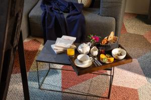 a tray of breakfast food on a coffee table at Hotel Le Colombier Suites in Colmar