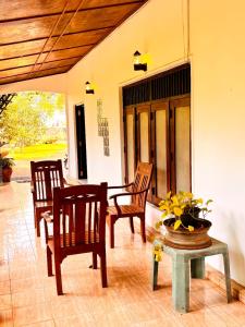 a patio with two chairs and a table and a table sidx sidx at Orchid Resort in Medawachchiya
