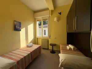 a room with two beds and a window at Hotel San Carlo in Cesenatico