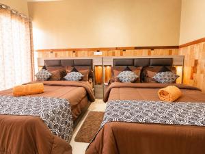 a bedroom with three beds in a room at Polo Region Rest Inn in Haputale