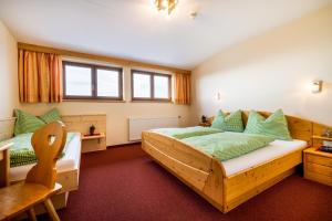 a bedroom with a wooden bed and a chair at Gasthof Kogelalm in Wagrain