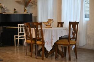 a dining room table with chairs and a piano at Hilltop Jikha in Jikhaskari