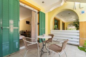 a patio with a table and chairs and a window at Lenia Studios in Kalamitsi