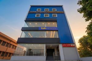 a tall blue building with a sign on it at FabHotel Saanidhya Comforts - Tumkur Road in Kunigal