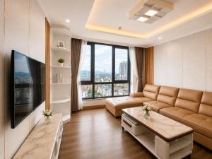 a living room with a couch and a large window at V Hạ Long in Ha Long