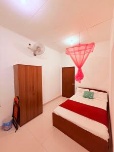 a bedroom with a bed and a dresser in it at Thalpe Gedara Villa in Talpe
