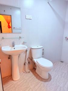 a bathroom with a white toilet and a sink at Thalpe Gedara Villa in Talpe +2 photos