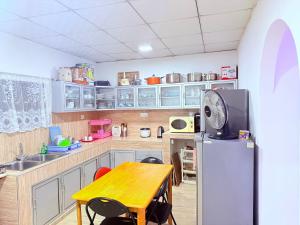 a kitchen with a wooden table and a refrigerator at Thalpe Gedara Villa in Talpe