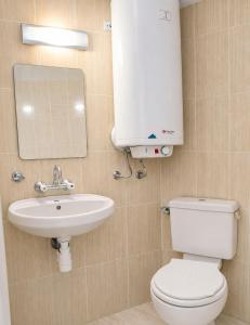 a bathroom with a toilet and a sink and a mirror at Къща за гости Уют in Sveti Vlas +22 photos