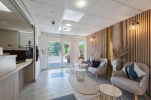 a living room with couches and chairs and tables at Comfort Aparthotel Cannes Mandelieu in Mandelieu-La Napoule