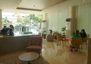 two people sitting at a table in a lobby at Ace Penzionne by Hiverooms in Pajo