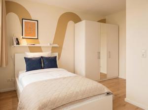 a small bedroom with a bed and a white cabinet at MOWO Kornwestheim in Kornwestheim
