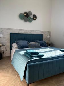 a bedroom with a blue bed with towels on it at Essenza di Mare Luxury B&B in Torre dell'Orso