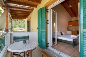 a room with a balcony with a bed and a table at Lenia Studios in Kalamitsi