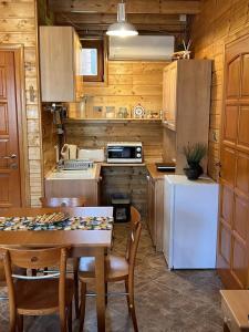 a kitchen with a table and a white refrigerator at Petőfi 35 Vendégház in Sirok