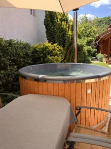 a hot tub with a table and an umbrella at Petőfi 35 Vendégház in Sirok