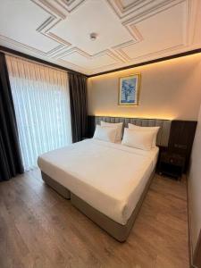 a bedroom with a large white bed in a room at Residence Hotel By Ketenci in İzmir