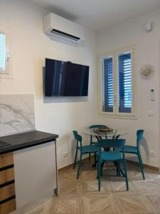 a dining room with a table and chairs and a tv on the wall at Essenza di Mare Luxury B&B in Torre dell'Orso