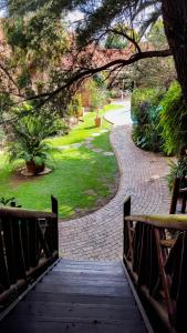a wooden bridge leading to a park with a walkway at Aark Guest Lodge in Vanderbijlpark