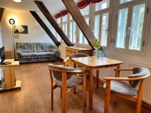 a living room with a table and chairs and a couch at Hotel TraumzeitHof in Eschede