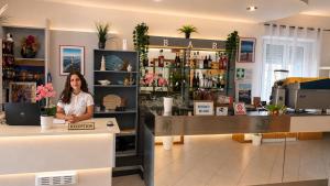 a woman standing behind a counter in a store at Hotel Malibù in Rimini
