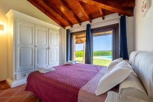 a bedroom with a bed and a large window at Villa Glory piscina privata in Cuile Pazzoni +23 photos