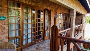 a screened porch with wooden doors and windows at Aark Guest Lodge in Vanderbijlpark