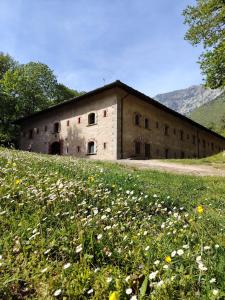 an old building in a field of flowers at Rifugio Forte di Machaby in Arnad