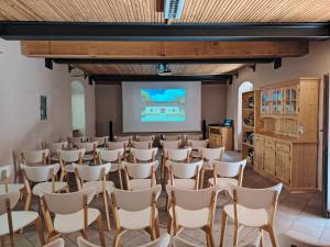 a room with rows of chairs and a projection screen at Rifugio Forte di Machaby in Arnad